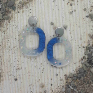 Variation der klassischen Creolen - oval abgerundete Ohrringe. Eingefärbt in blau weiß mit feinen Silbersternchen.