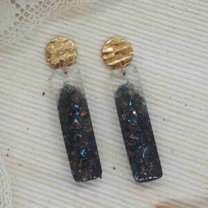 Ohrringe - Längliche Epoxidharzanhänger mit schwarzem Farbverlauf mit Gitzerelementen. Dazu runde goldfarbene Ohrrignstecker mit interessanter unregelmässiger wellenförmiger Oberfläche