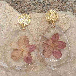 Tropfenförmige Ohrringe uas klarem Epoxidharz mit getrockeneten Hortensienblüten.